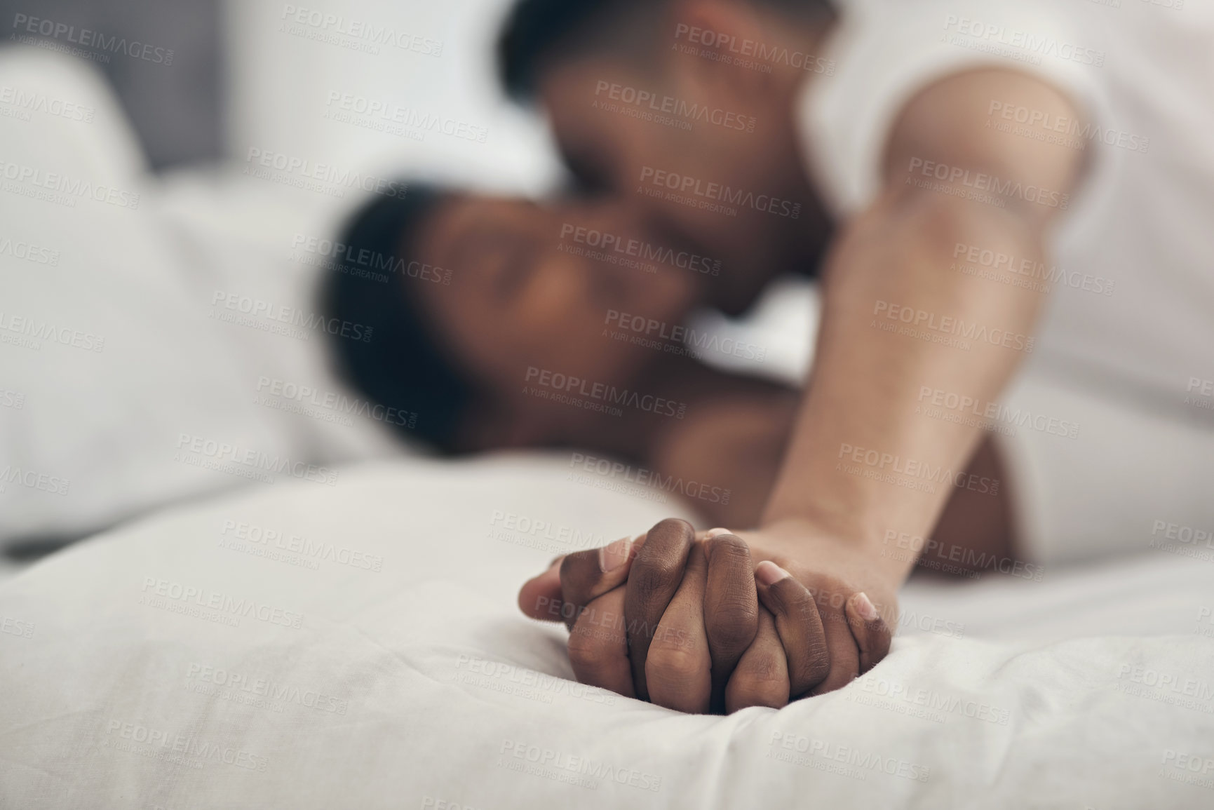 Buy stock photo Shot of a young couple sharing an intimate moment in bed at home