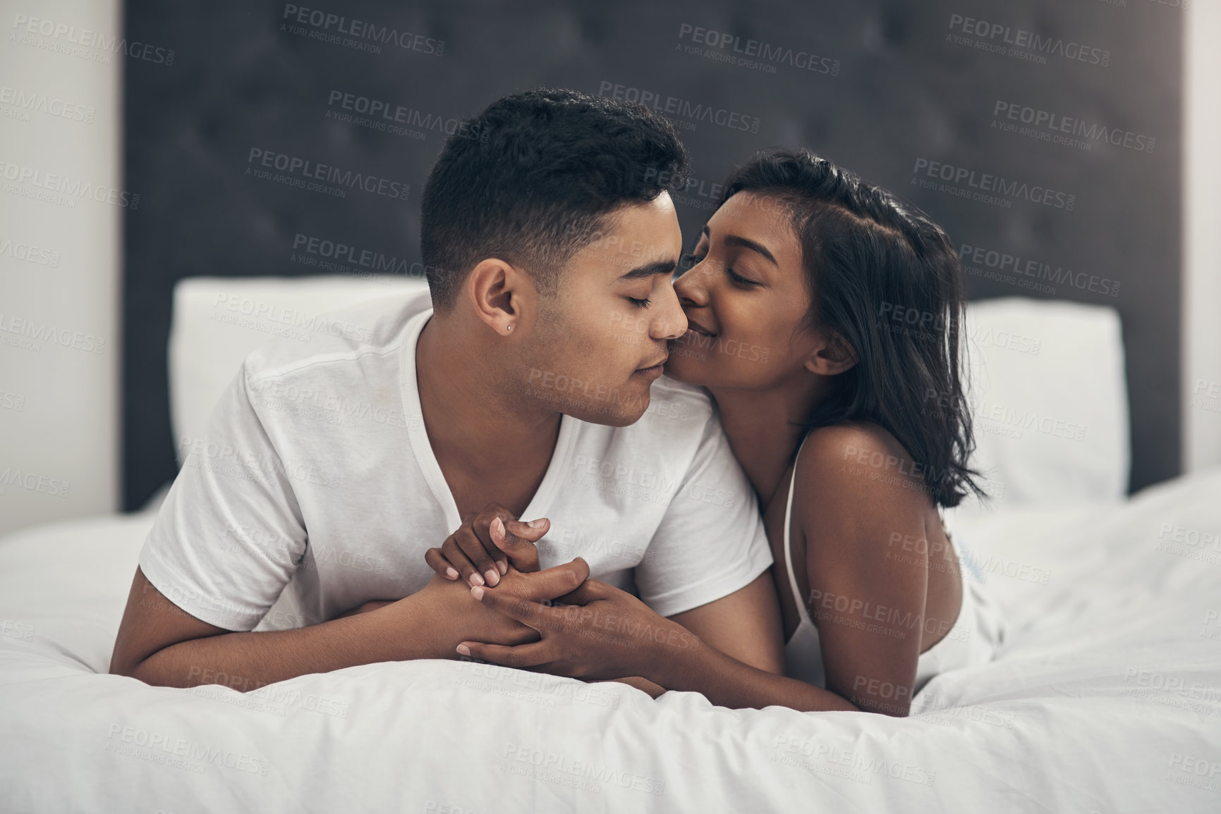 Buy stock photo Shot of a young couple sharing an intimate moment at home