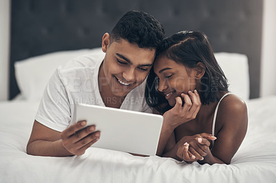 Buy stock photo Shot of a young couple using a digital tablet at home