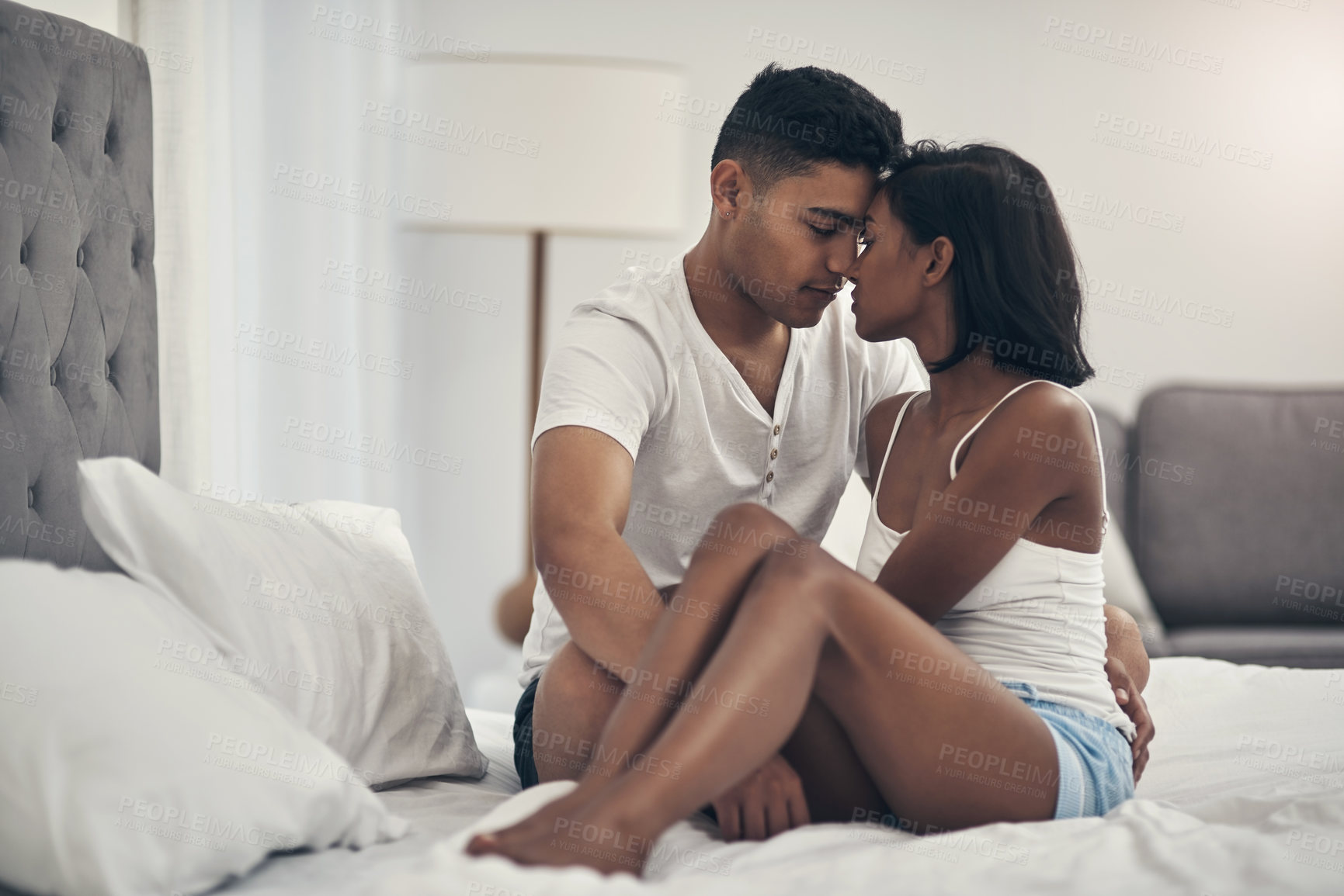 Buy stock photo Shot of a young couple sharing an intimate moment at home