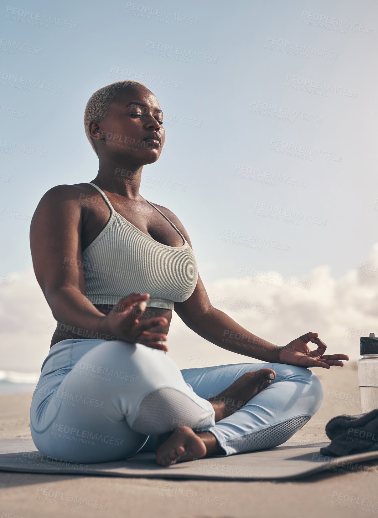 Buy stock photo Shot of a woman meditating during her yoga routine on the beach