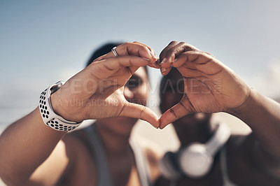 Buy stock photo Shot of two sporty young women forming a heart shape with their hands