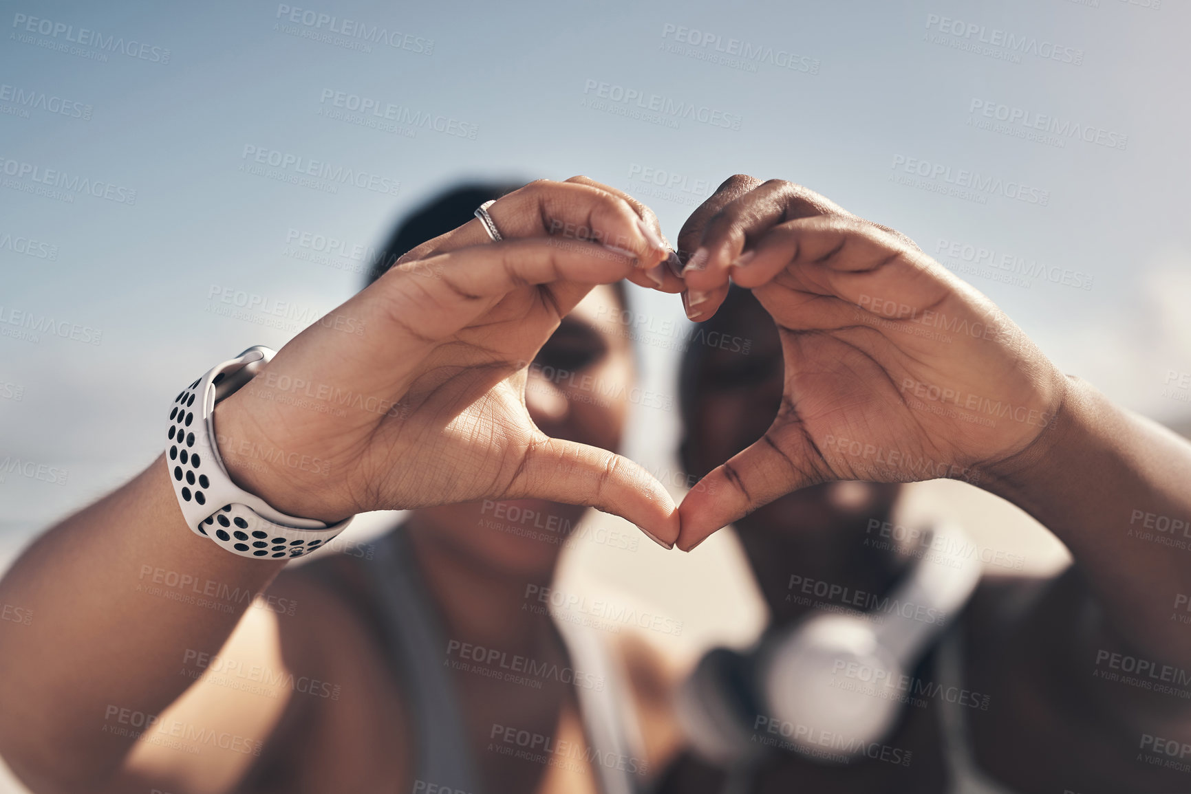 Buy stock photo Shot of two sporty young women forming a heart shape with their hands