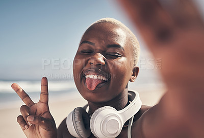 Buy stock photo Shot of a sporty young woman posing with headphones around her neck