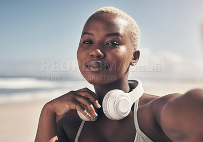 Buy stock photo Shot of a sporty young woman posing with headphones around her neck