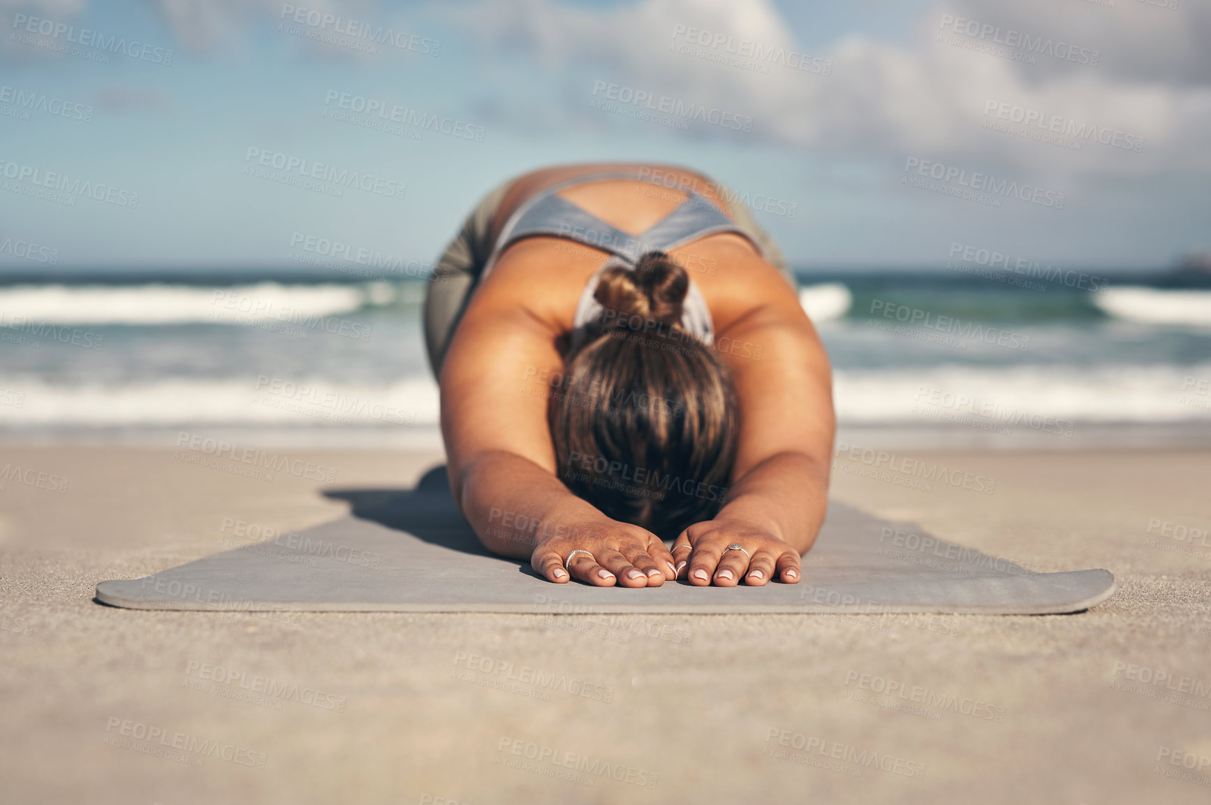 Buy stock photo Shot of a young woman practicing yoga on the beach