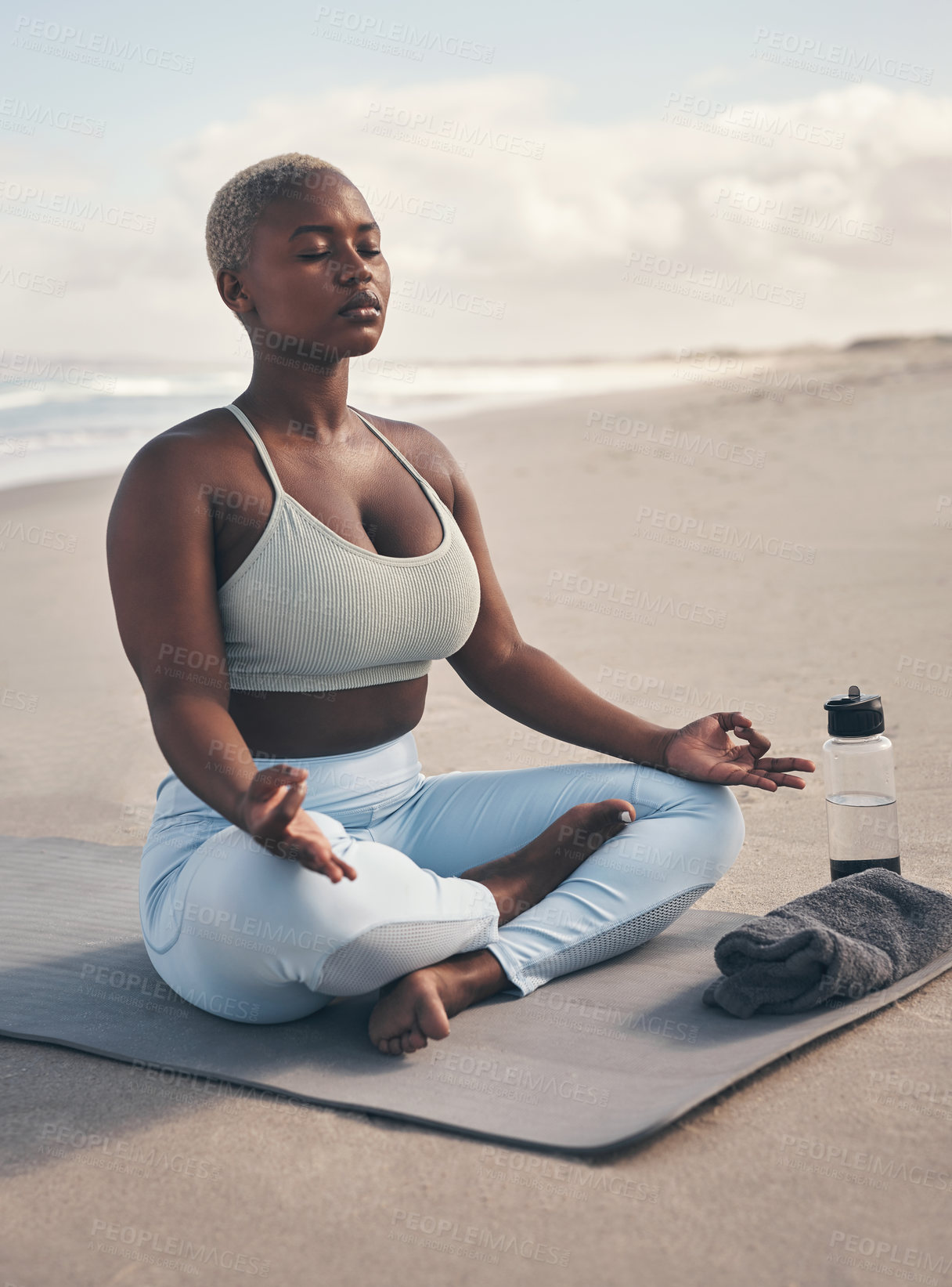 Buy stock photo Shot of a woman meditating during her yoga routine on the beach