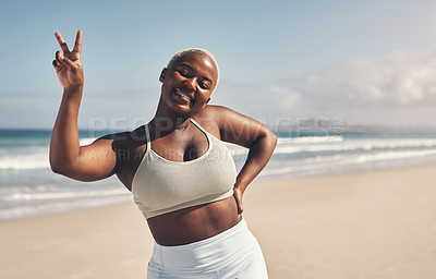 Buy stock photo Shot of a young woman showing the peace sign while out for a workout