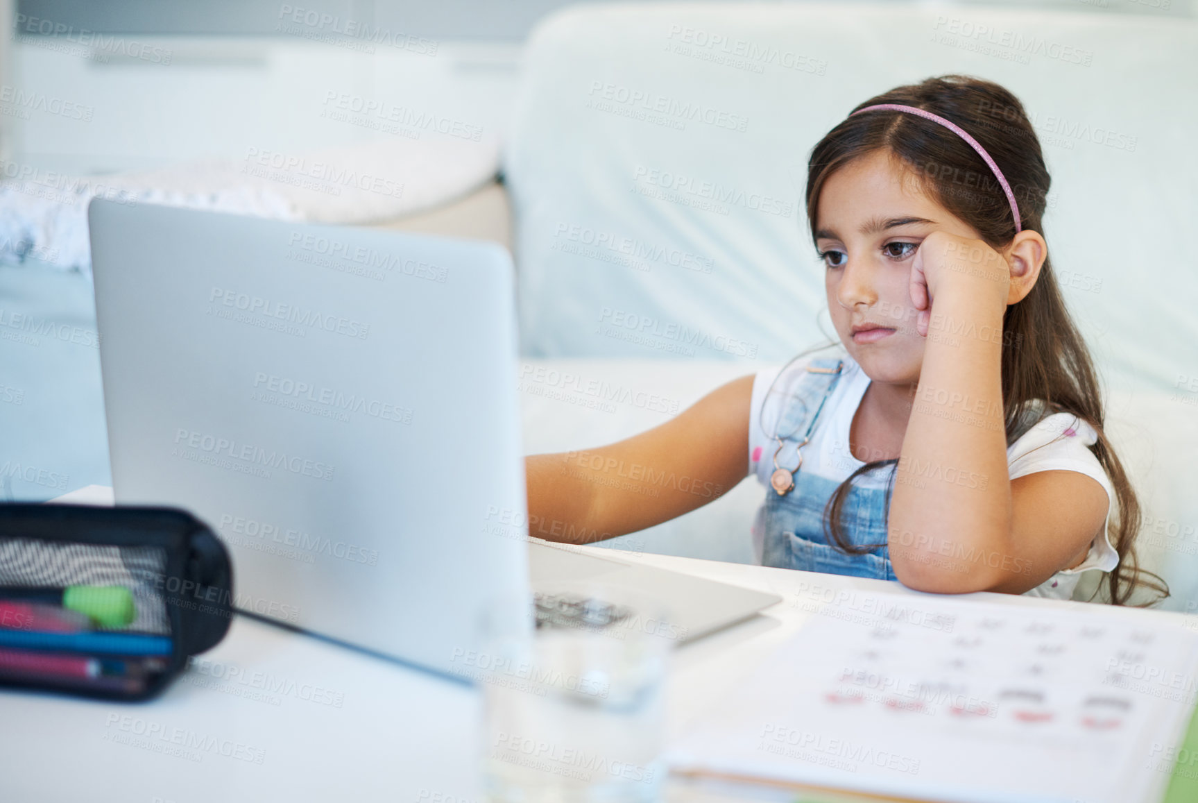 Buy stock photo Bored, child and homework with laptop by table for education, online class and lesson at home. Tired, girl and student with technology in living room for elearning, fatigue or problem with connection