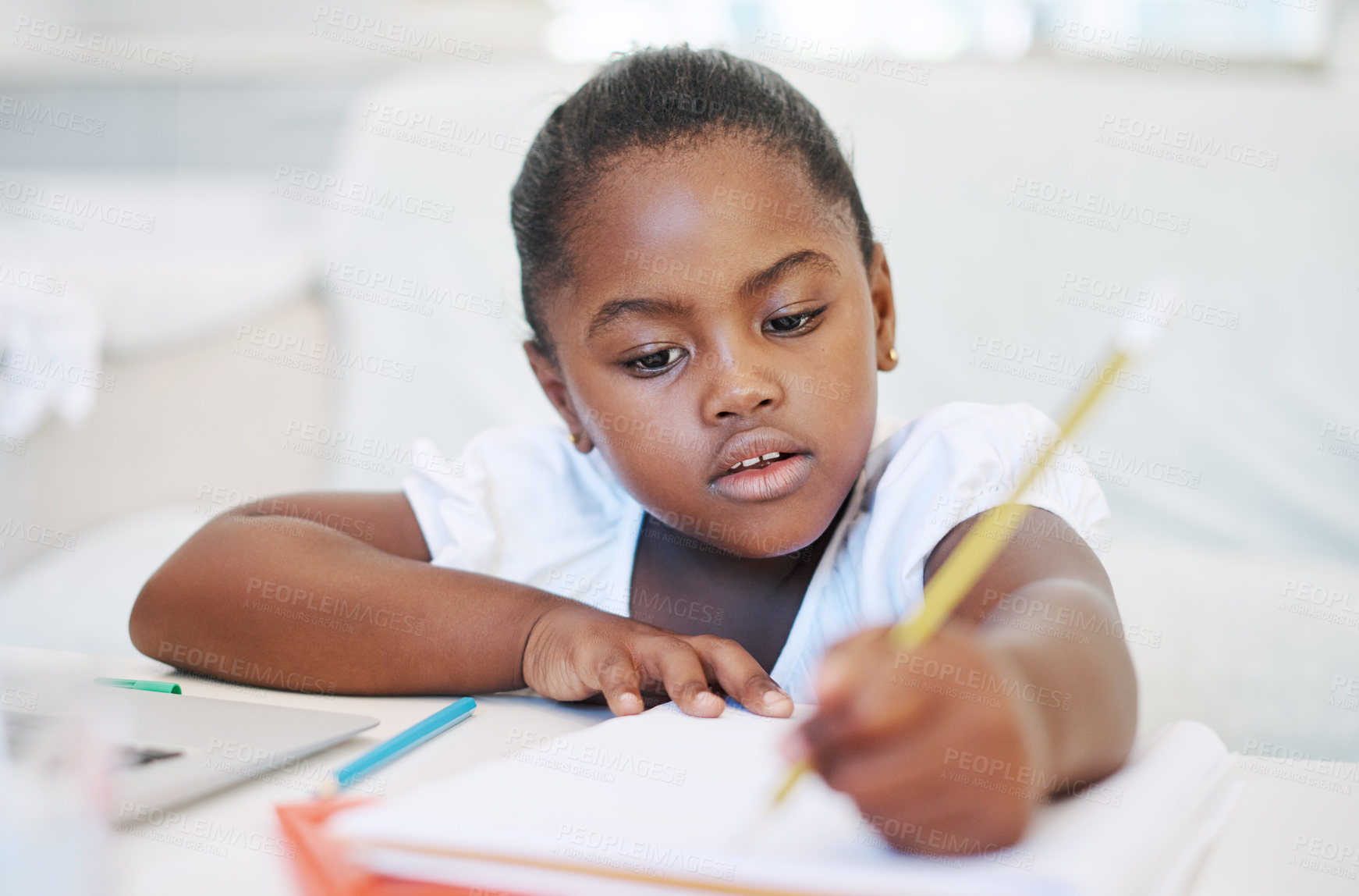 Buy stock photo Drawing, learning and black child by desk in home for development, homework and knowledge. Creative, writing and young girl student with pencils for assignment, project or school test at house.