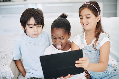 Buy stock photo Shot of a group of little children using a digital tablet at home