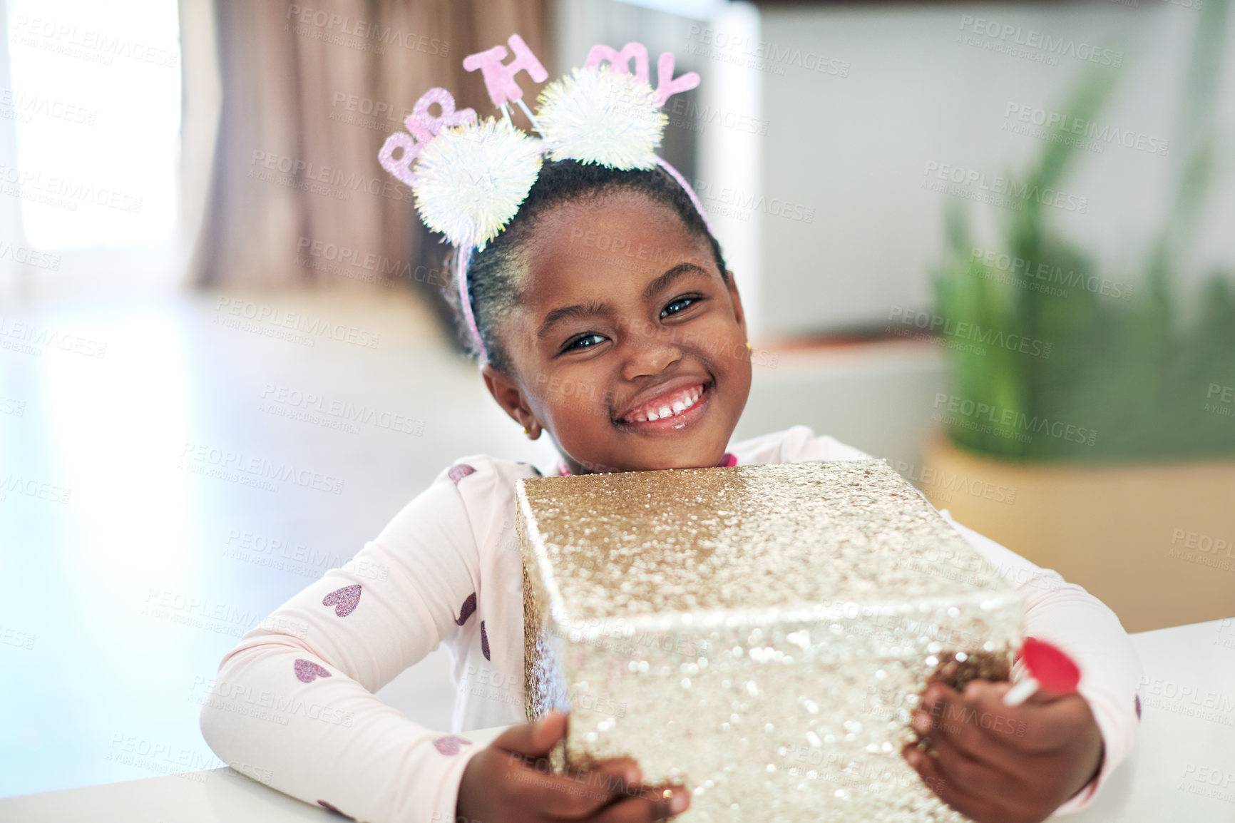 Buy stock photo Shot of a little girl holding on to a gift box on her birthday