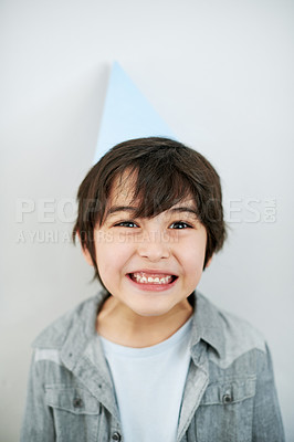 Buy stock photo Happy, party hat and portrait of Asian child in studio for birthday celebration or event. Smile, sweet and confident young boy kid with accessory for festive activity isolated by white background.