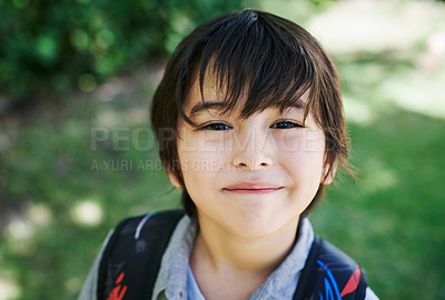 Buy stock photo Shot of a little boy wearing a backpack in nature