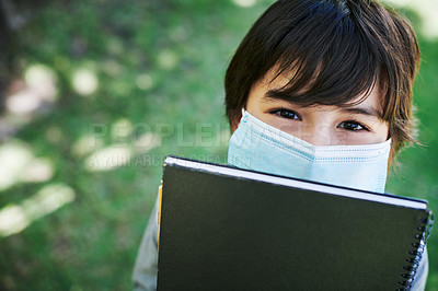 Buy stock photo Shot of a little boy wearing a mask and holding books in nature