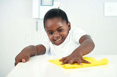 Buy stock photo African child, cloth and cleaning table in home kitchen for hygiene, chores and housekeeping maintenance. Happy girl, kid and wipe counter for learning housework, education or help for development