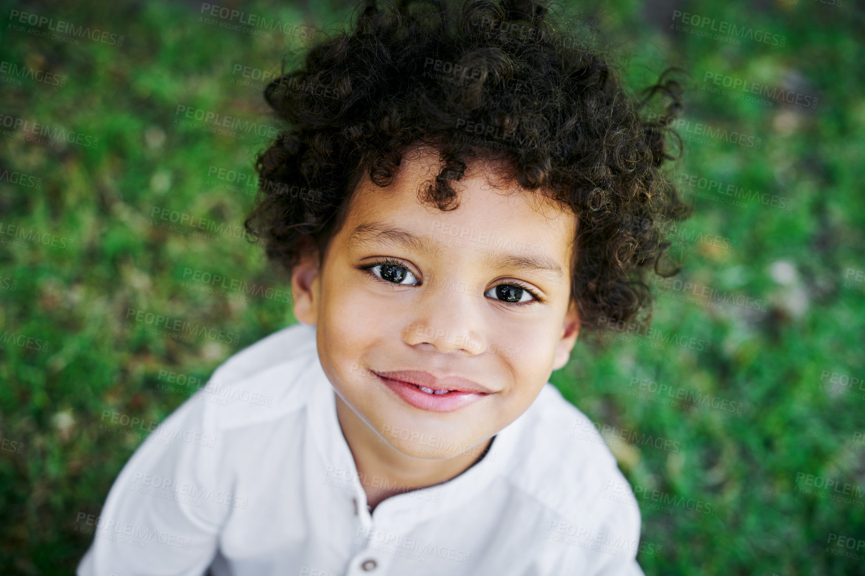 Buy stock photo Smile, top view and portrait of child outdoor in nature for holiday, vacation or travel in Brazil. Face, cute boy and happy young kid at park on grass for summer, playing or recreation for childhood