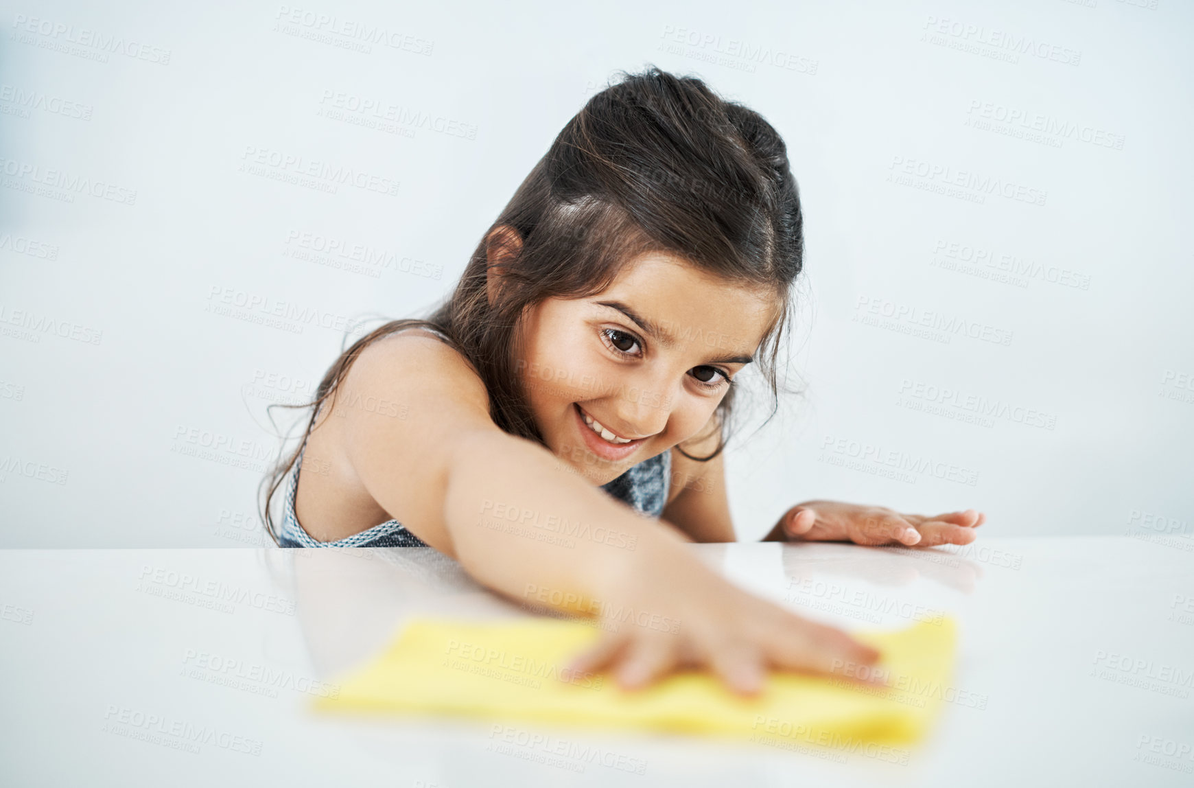 Buy stock photo Happy child, cloth and cleaning table in home for hygiene, chores and housekeeping maintenance. Girl, kid and wipe kitchen counter for learning housework, education or help for development in house