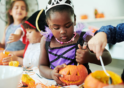 Buy stock photo Shot of a group of little children cleaning pumpkins at a party