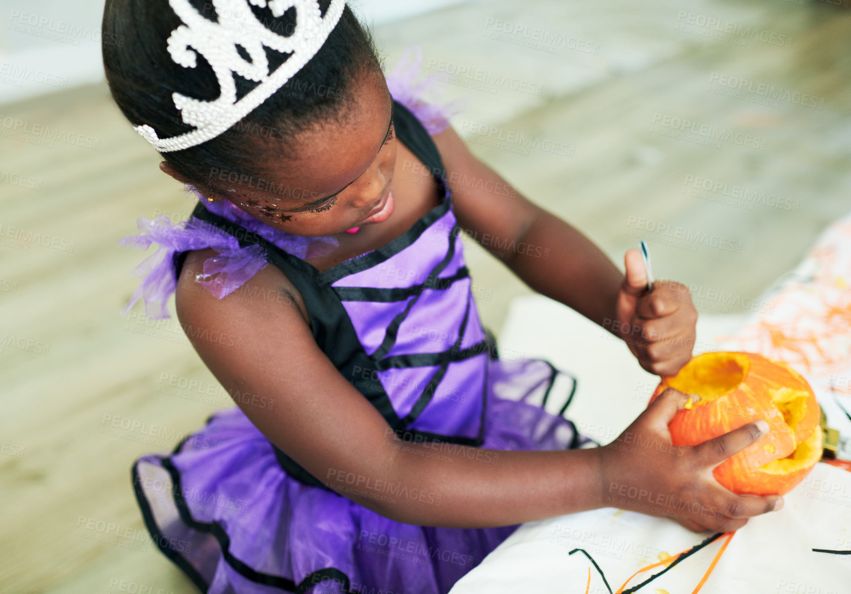 Buy stock photo Shot of a little girl cleaning a pumpkin at a party