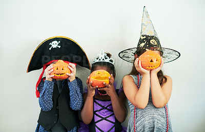 Buy stock photo Shot of a group of unrecognizable little children covering their faces with pumpkins at a party