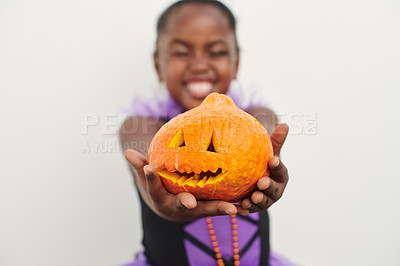 Buy stock photo Shot of a little girl holding a jack o lantern against a white background