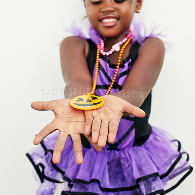 Buy stock photo Shot of a little girl holding a jack o lantern pendant in her hands against a white background
