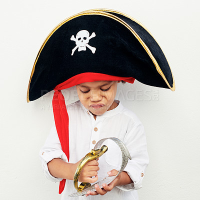 Buy stock photo Shot of a little boy wearing a pirate hat while holding a play sword against a white background
