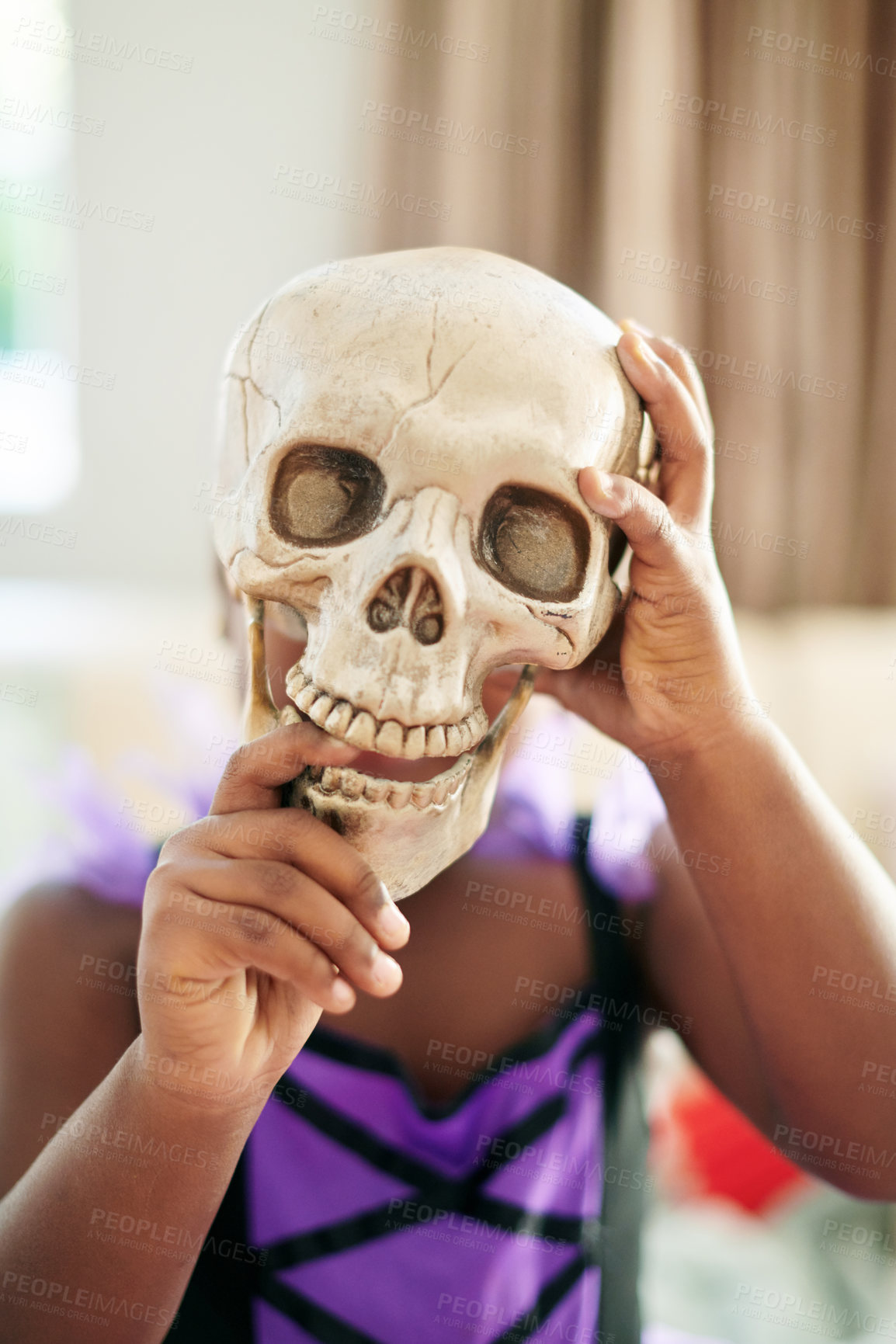 Buy stock photo Shot of an unrecognizable little child covering their face with a skull