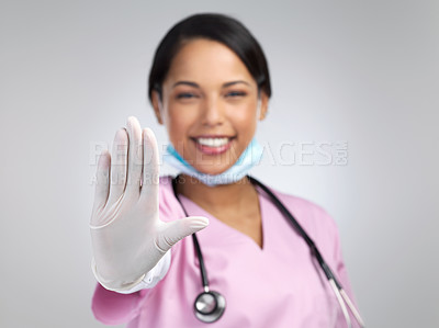 Buy stock photo Cropped portrait of an attractive young female healthcare worker gesturing stop while standing in studio against a grey background