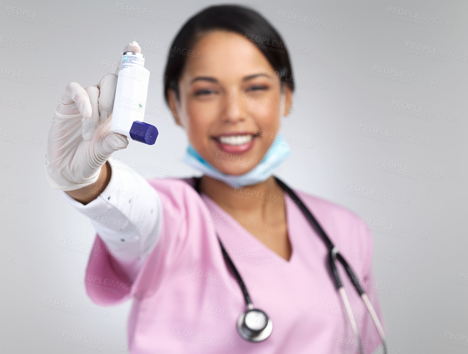 Buy stock photo Cropped portrait of an attractive young female healthcare working holding up an asthma pump in studio against a grey background