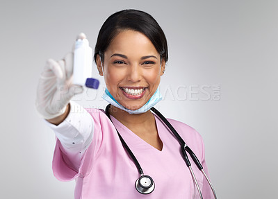 Buy stock photo Cropped portrait of an attractive young female healthcare working holding up an asthma pump in studio against a grey background