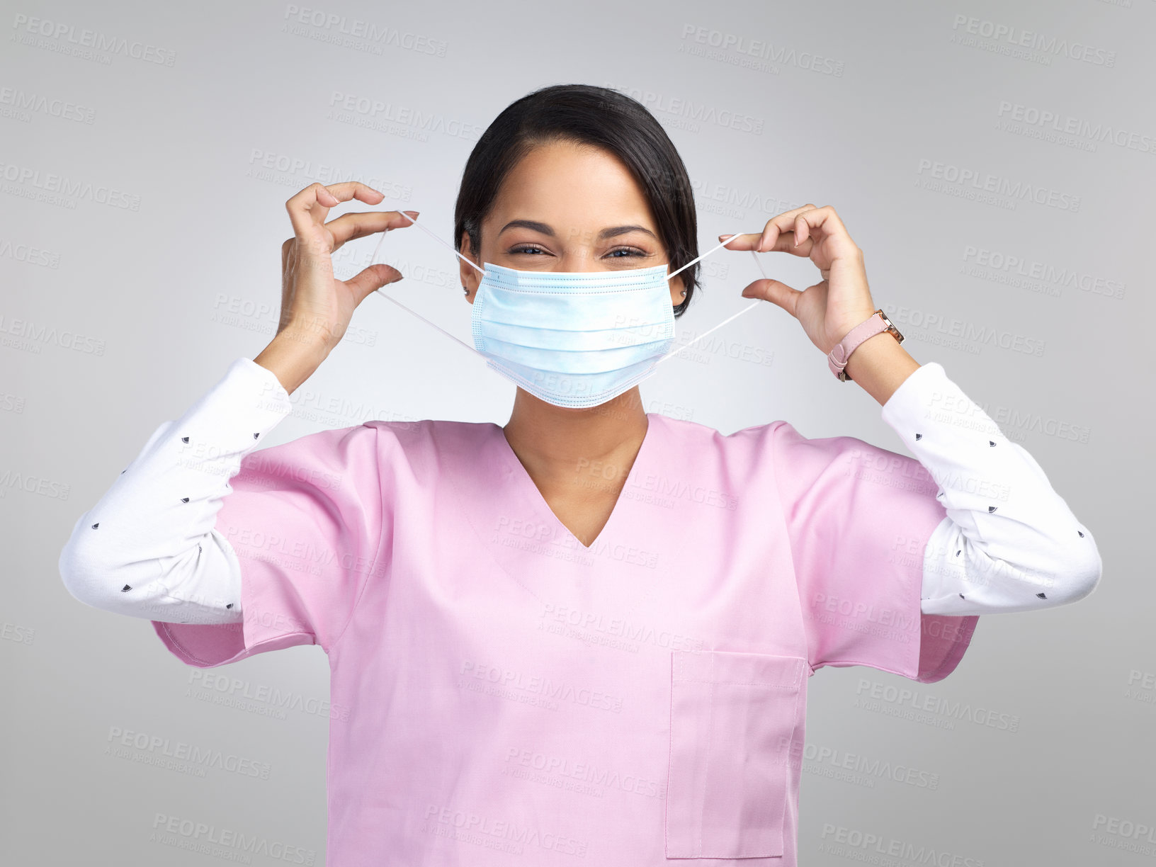 Buy stock photo Cropped portrait of an attractive young female healthcare worker wearing a mask and standing in studio against a grey background