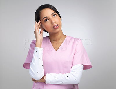 Buy stock photo Cropped shot of an attractive young female healthcare worker looking stressed while standing in studio against a grey background