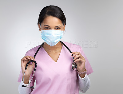 Buy stock photo Cropped portrait of an attractive young female healthcare worker wearing a mask and stethoscope while standing in studio against a grey background