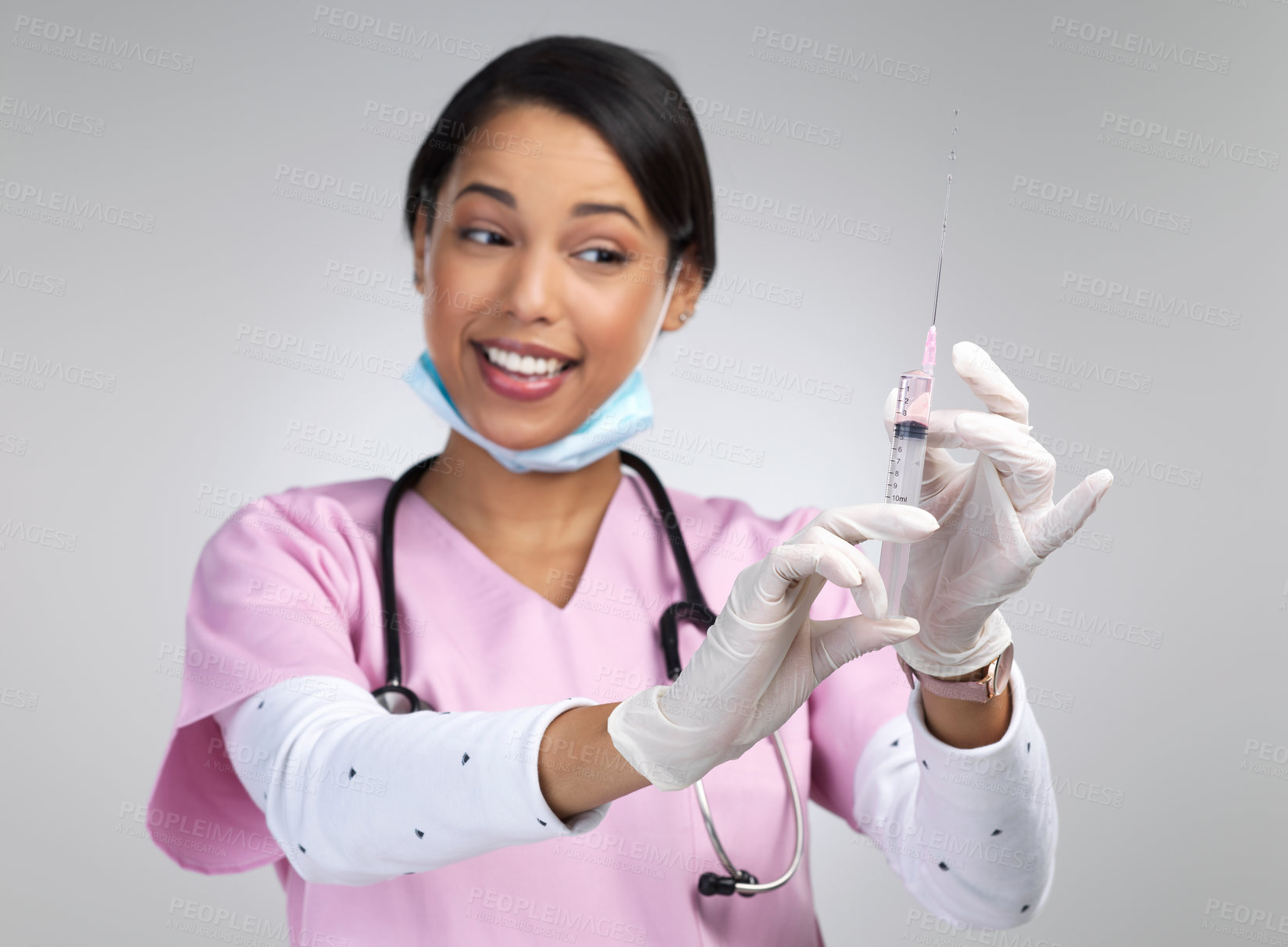 Buy stock photo Cropped shot of an attractive young female healthcare working holding up a syringe in studio against a grey background