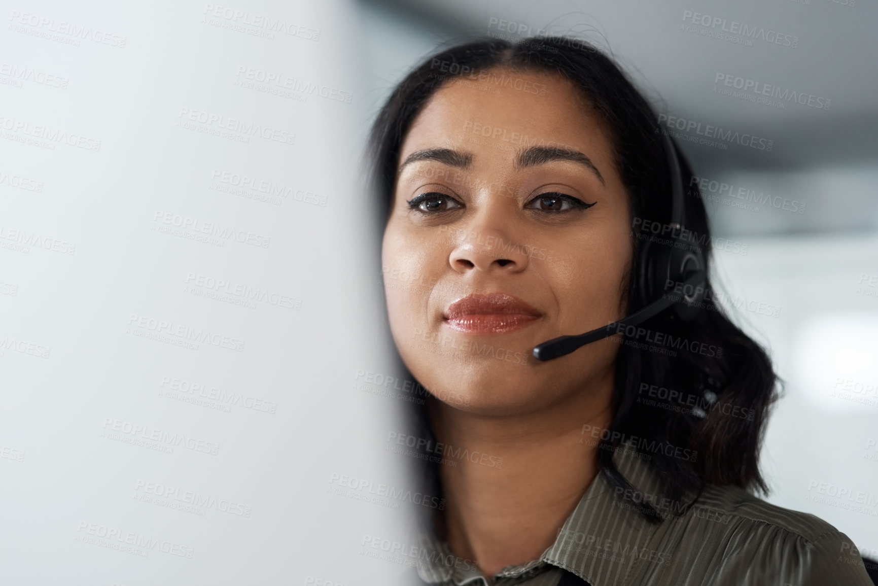 Buy stock photo Shot of a young businesswoman wearing a headset while working in a call centre