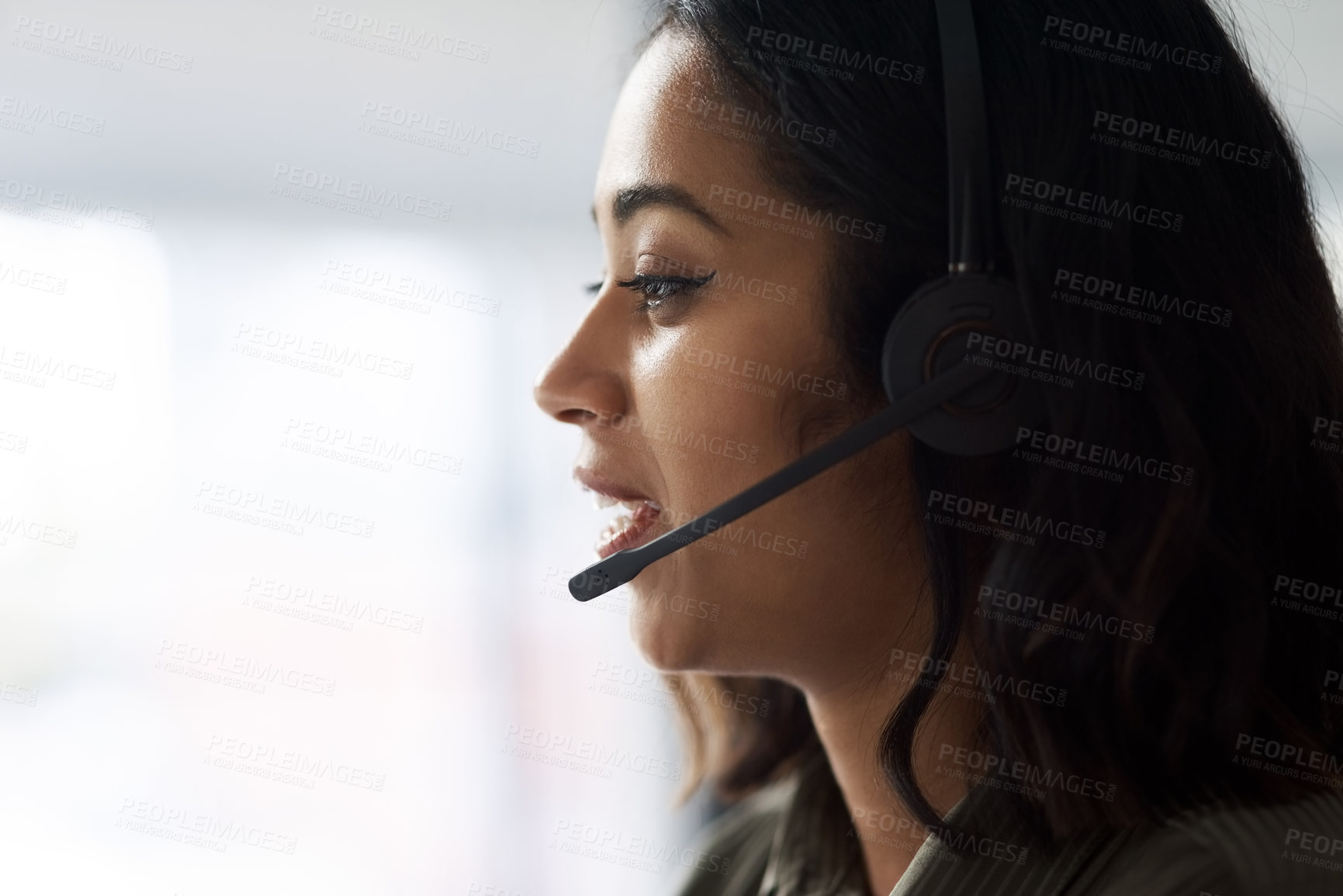 Buy stock photo Shot of a young businesswoman wearing a headset while working in a call centre