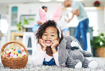 Buy stock photo Shot of a young girl sitting on the floor with easter eggs at home