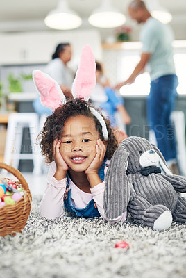 Buy stock photo Shot of a young girl sitting on the floor with easter eggs at home
