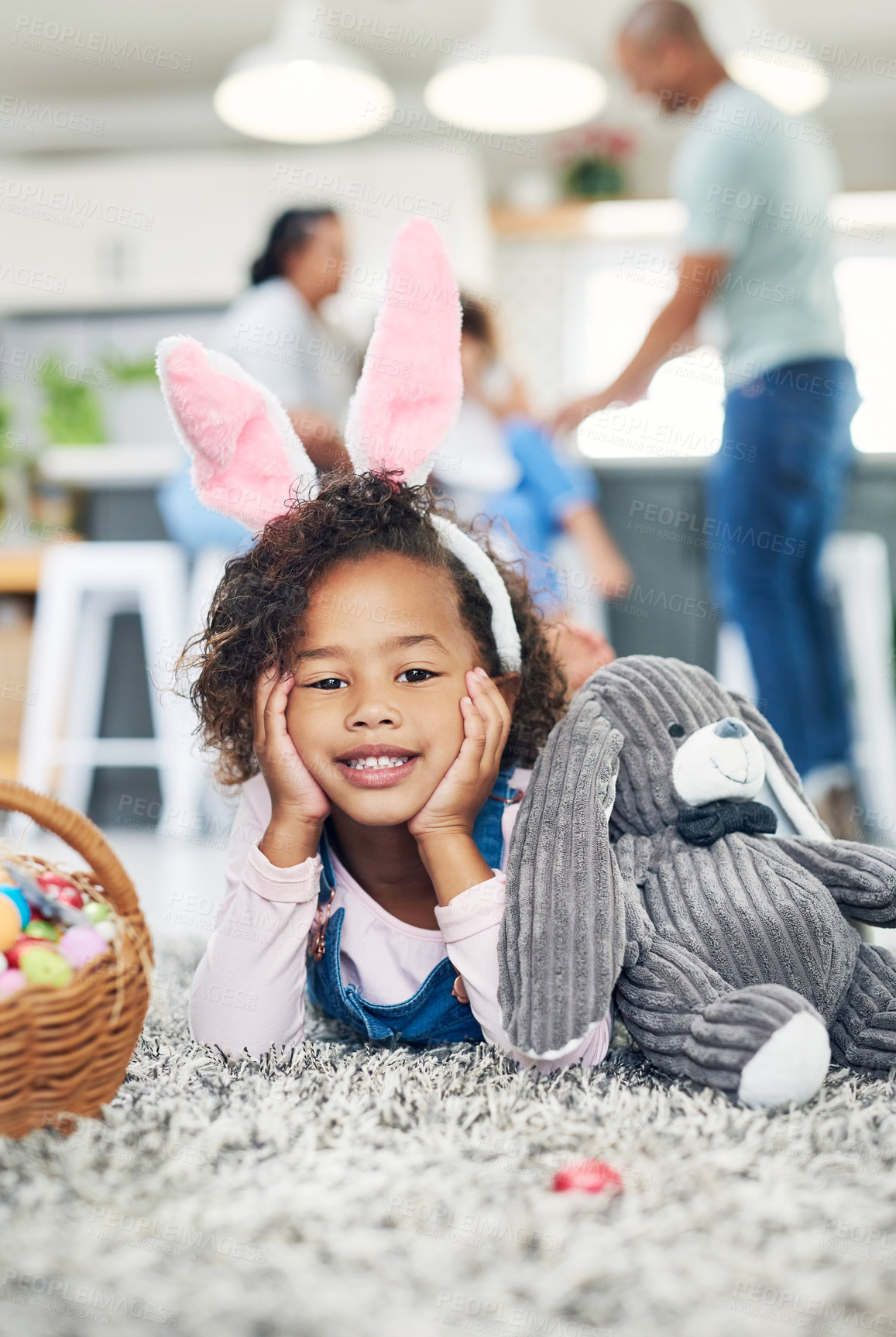 Buy stock photo Shot of a young girl sitting on the floor with easter eggs at home