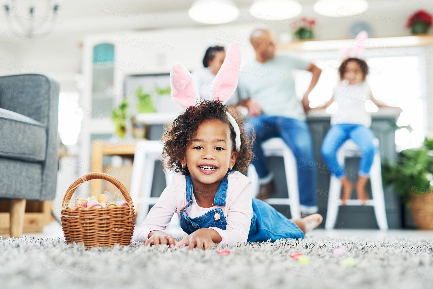 Buy stock photo Shot of a young girl sitting on the floor with easter eggs at home