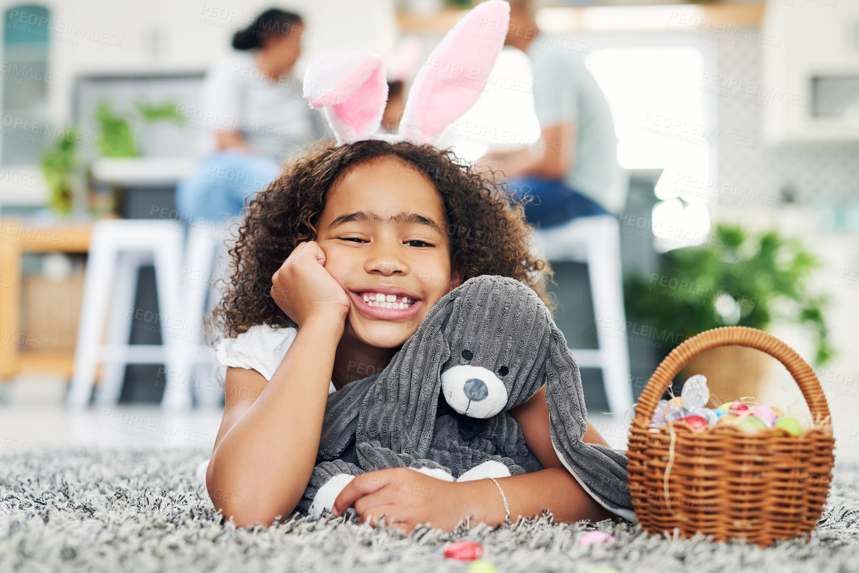 Buy stock photo Shot of a young girl sitting on the floor with easter eggs at home