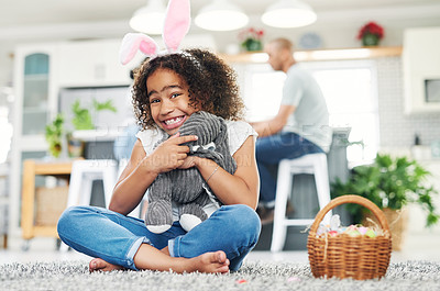 Buy stock photo Shot of a young girl sitting on the floor with easter eggs at home