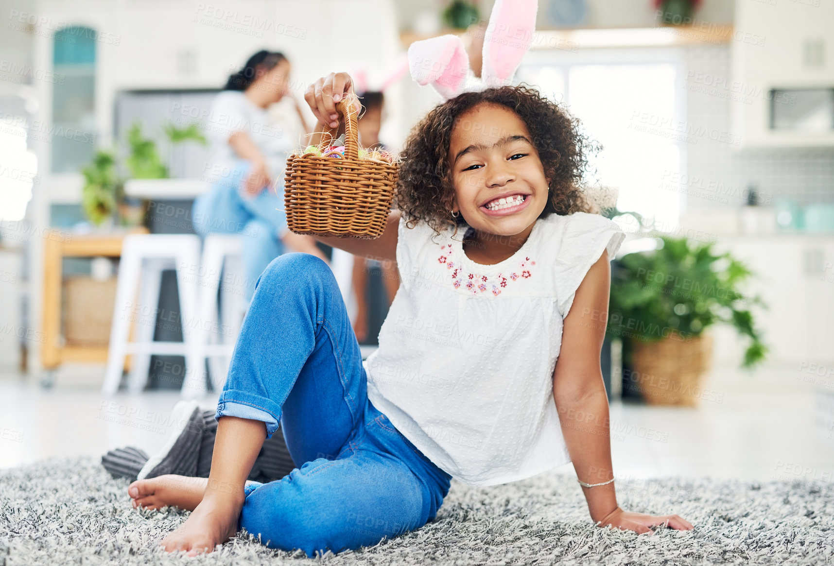 Buy stock photo Shot of a young girl sitting on the floor with easter eggs at home