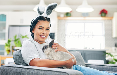 Buy stock photo Shot of a young woman playing a rabbit at home
