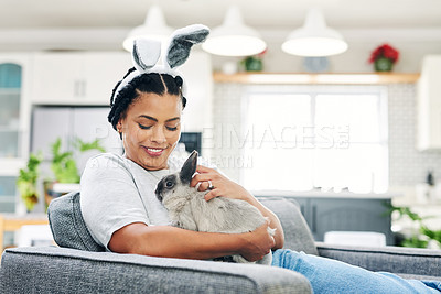 Buy stock photo Shot of a young woman playing a rabbit at home