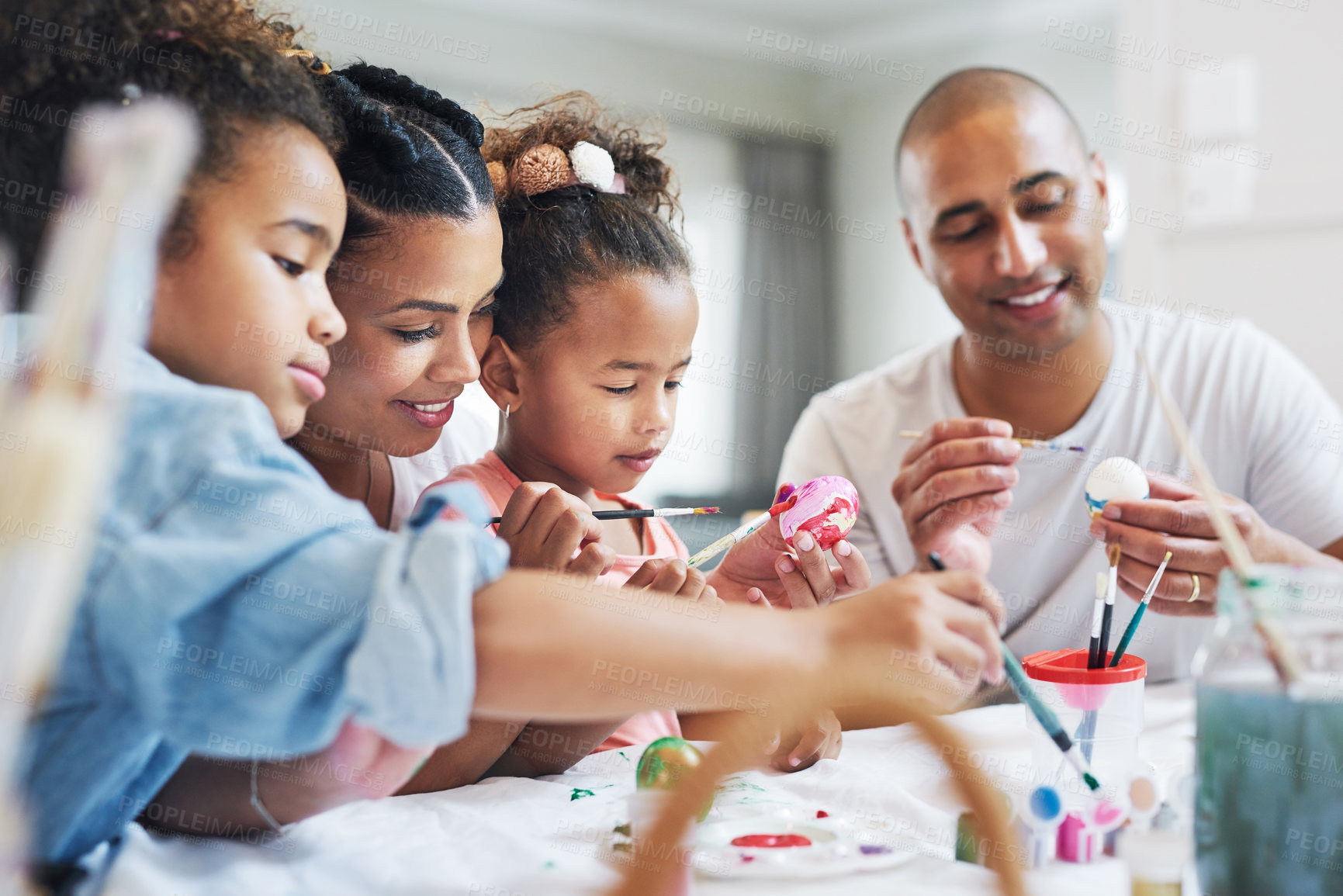 Buy stock photo Shot of a mother and father painting eggs with their daughter at home