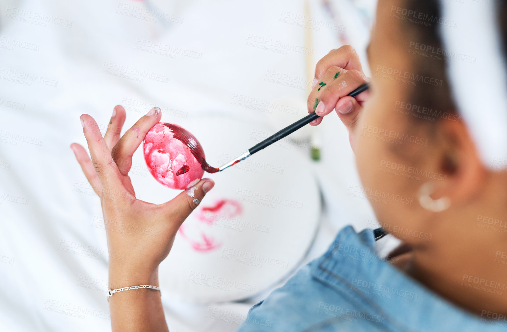 Buy stock photo Cropped shot of a unrecognizable girl painting eggs at home