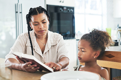 Buy stock photo Shot of a mother teaching her daughter about the bible at home